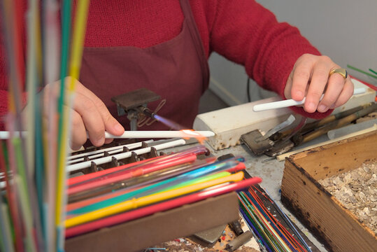 Murano glass artisan shaping glass with torch - Powered by Adobe