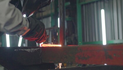 A skilled worker expertly welds metal pieces together in a workshop setting, producing sparks and heat.