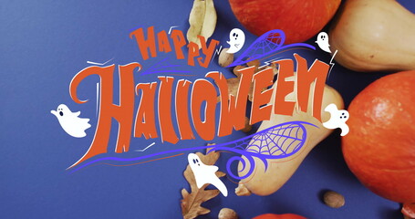 Happy Halloween text image over autumn leaves and pumpkins on blue background