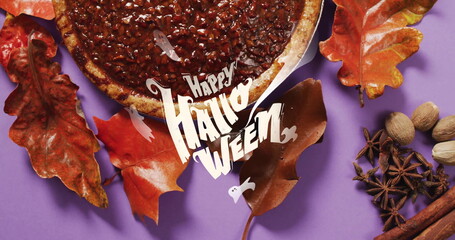 Happy Halloween text image over autumn leaves and pie on purple background