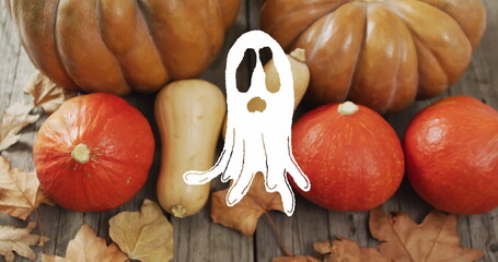 Ghost image over pumpkins and autumn leaves on wooden surface