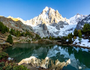 Naklejka premium Majestic alpine lake reflecting a snow-capped peak