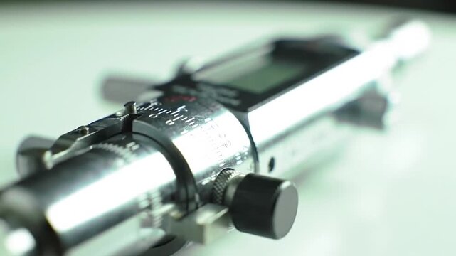 A close-up shot of a shiny metallic digital precision measuring instrument, possibly a micrometer or caliper, used in industry or science.