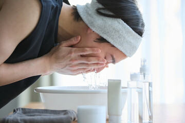 顔を洗う若いアジアの男性