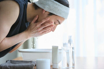 顔を洗う若いアジアの男性