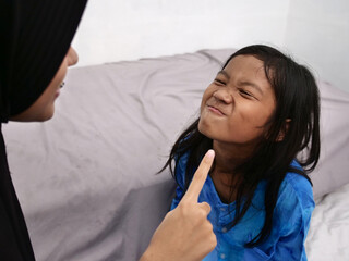 Two Asian muslim girls siblings joking playing laughing having fun before bed time
