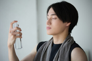 化粧水を浴びるアジアの若い男性