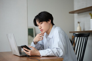 自宅で仕事をしているアジアの若い男性