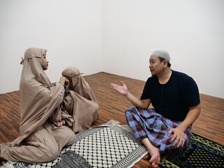 Asian muslim father talking to his daughters after salah pray, communication discussion giving advice