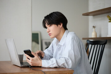 自宅で仕事をしているアジアの若い男性