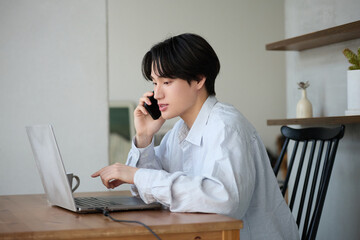 自宅で仕事をしているアジアの若い男性