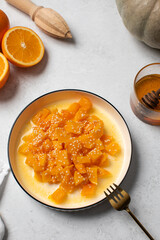 Healthy dessert with sliced pumpkin, honey and orange juice in a bowl. Healthy pumpkin dish.