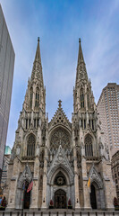 The St. Patrick s Cathedral with its ornate gothic architecture and spires, surrounded by modern skyscrapers in New York City, decorated for Christmas