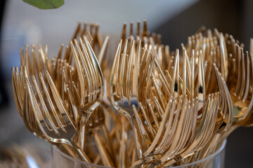 Large supply of golden plastic forks for the wedding guests to use for dinner