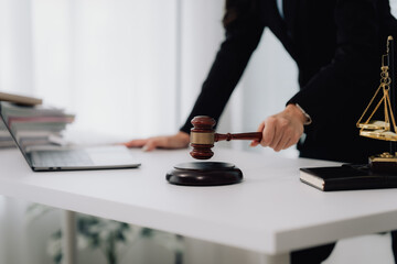 Fototapeta premium Attractive young lawyer in office Business woman and lawyers discussing contract papers with brass scale on wooden desk in office. Law, legal services, advice, Justice and real estate concept.