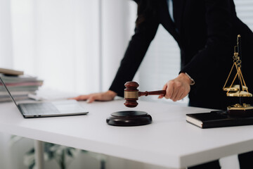 Attractive young lawyer in office Business woman and lawyers discussing contract papers with brass scale on wooden desk in office. Law, legal services, advice, Justice and real estate concept.