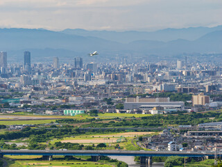 伊丹空港を飛び立つ旅客機と都市景観