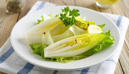 Fresh endive salad with lemon, herbs, and spices on a white plate