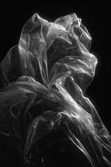 Naklejka premium Translucent plastic draped in abstract form against a black backdrop