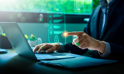 Business compliance and digital document security concept with businessman using laptop and holographic checklist interface for data protection, regulation, and secure online management system