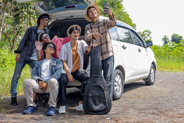 Group of Friends Pose For A Selfie on Car Trunk, Taking A Break From Their Road Trip Adventure