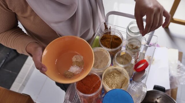 Asian muslim woman mixing spices and herbs