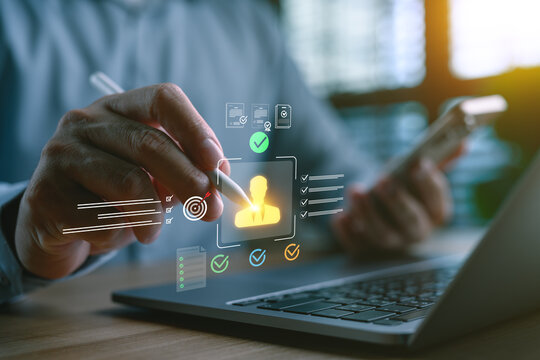 Hand holding stylus pointing at virtual candidate profile with checklist and approval icons on laptop screen, concept of human resources, recruitment process, employee evaluation and selection system.