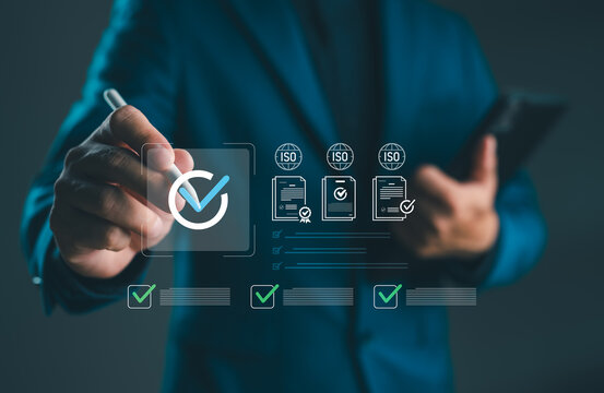 Businessman using digital pen to approve ISO certification standard with check mark icon and quality documents, concept of quality assurance, compliance and international standard.