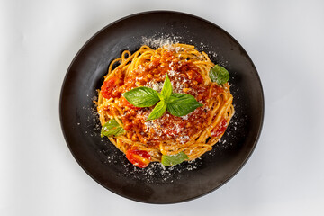 Pasta spaghetti bolognese with minced beef sauce, tomatoes, parmesan cheese and fresh basil in a plate