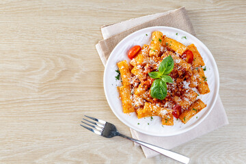 Classic italian pasta penne alla arrabiata with basil and freshly grated parmesan cheese.