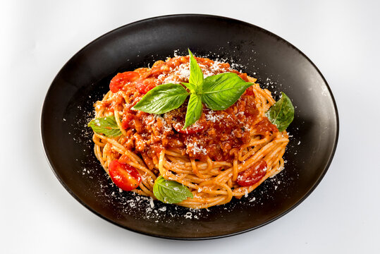 Pasta spaghetti bolognese with minced beef sauce, tomatoes, parmesan cheese and fresh basil in a plate