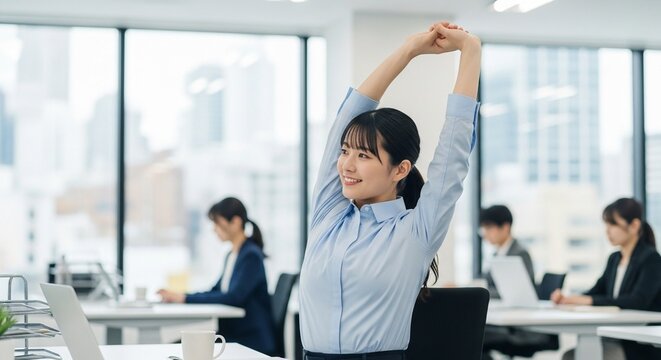 リフレッシュタイム：デスクワークの合間に軽くストレッチをする日本人女性社員