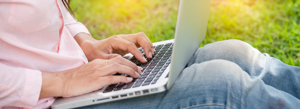 Banner Close up businesswoman hand typing laptop drink black coffee cup in green garden cafe. Banner Woman Hands love drinking hot coffee working from home. Businesswoman black coffee with copy space