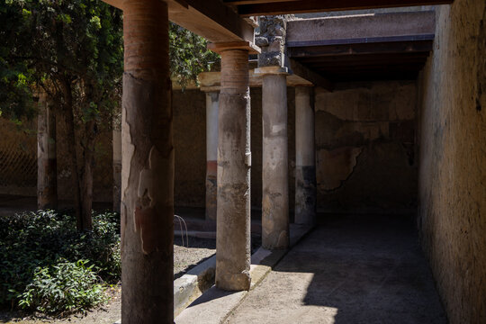 Ancient stone columns with partial shadows in courtyard ruins.