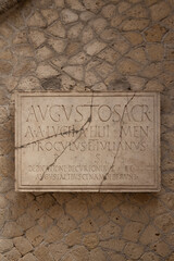 Ancient stone wall with Latin inscription plaque.