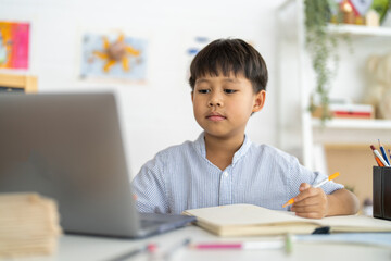 Asian boy using laptop with course online learning, distance education for kids, e-learning at...