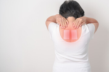 Business woman having back ache with Medicated pain relief patch plaster for Back Muscle Strain,...