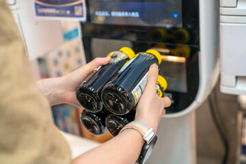 Person using a vending machine to get several bottles of drink