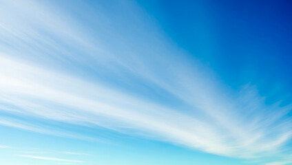 Blue sky with white cirrus clouds creating a bright airy atmosphere, reflecting the clarity of daylight, natural softness, and the peaceful openness of wide horizons.