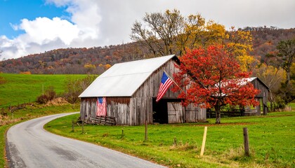 Obraz premium A rustic wooden barn with an American flag, framed by a winding road and colorful autumn foliage.