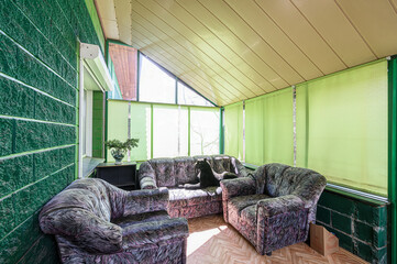 cozy sunroom with a sofa, armchair, green walls, and a panther statue
