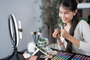 beauty blogger Young Asian girl makeup artist Professional Woman blogger vlogger is showing cosmetics products with recording video Beauty influencer asian girl video online marketing live streaming