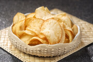 Keripik Singkong. Cassava chips are a snack or treat made from thin slices of cassava that are...