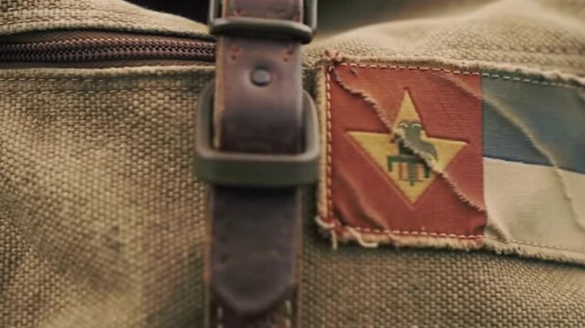 A vintage, weathered travel backpack leaning against a wall, covered in patches, a symbol of a long journey and countless adventures.