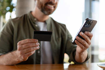 Man paying online using credit card and smartphone