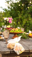 Naklejka premium Outdoor table setting with food and a plastic bag of sandwiches
