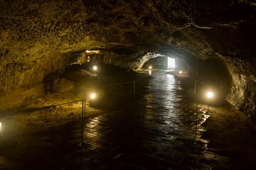Backlit exit and tiled floor inside lava tube