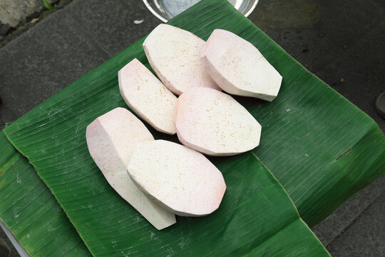 Freshly sliced taro or ubi talas on a vibrant banana leaf. A popular and nutritious root vegetable in Asian cuisine, perfect for cooking or dessert.