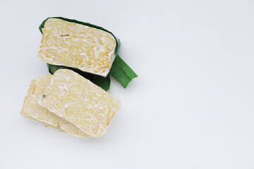 Fresh, raw tempeh wrapped in a banana leaf, a traditional way of fermenting this healthy Indonesian...