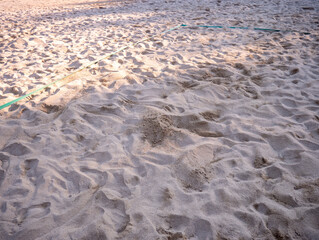 Sandy beach volleyball court with visible green boundary lines, photographed in Croatia, showing textured sand surface used for summer seaside sports and recreation.